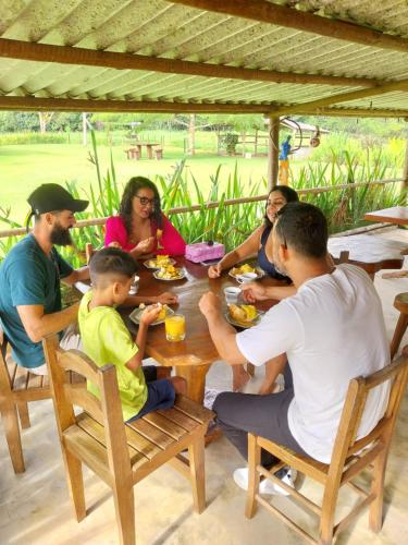 a group of people sitting around a wooden table at Pousada Rancho Sêmani in Itacaré