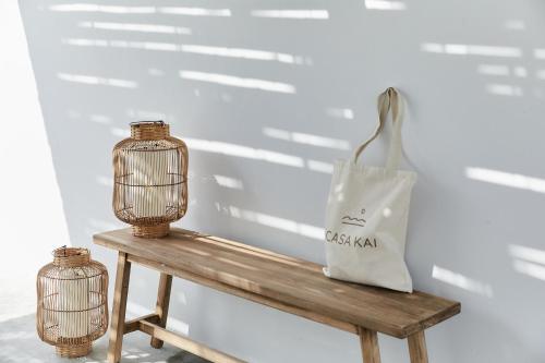 a bird cage and a bag on a wooden bench at Casa Kai in José Ignacio