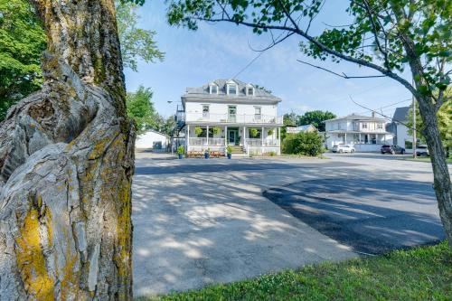 a white house on a street with a tree at Chambre 305 de l'hôtel Victoria confortable et moderne in Saint-Pascal