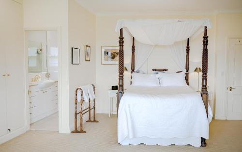 a bedroom with a white bed with a canopy at Macksville Cottage Robertson in Robertson