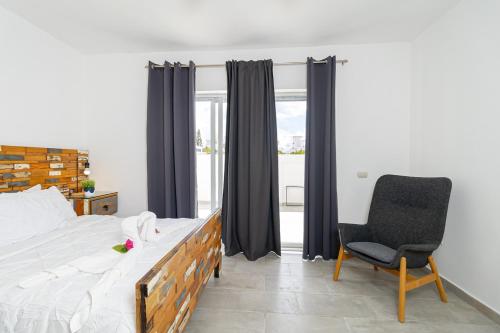 a bedroom with a bed and a chair and a window at Coastal Luxury 2-Bed w Pool Access in Bayahibe in Bayahibe