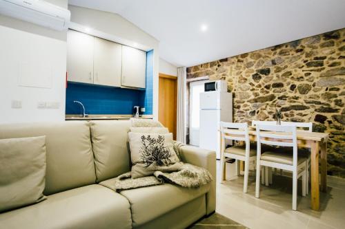 a living room with a couch and a table and a kitchen at Vougaldeias Casas da Seara in Sever do Vouga