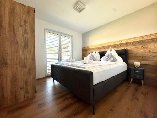 a bedroom with a large bed with a wooden wall at Alpin Apartments in Radstadt