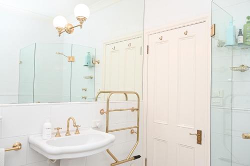 a bathroom with a sink and a mirror at Macksville Cottage Robertson in Robertson