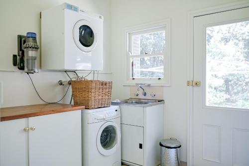 a white laundry room with a washer and dryer at Macksville Cottage Robertson in Robertson