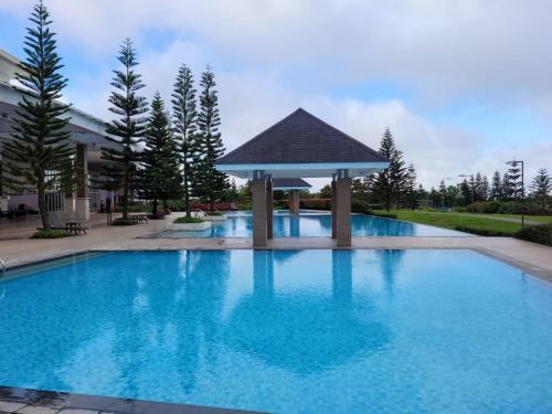 a large blue swimming pool with a gazebo at The Humble Abode in Tagaytay