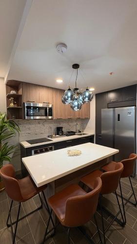 a kitchen with a white table and some brown chairs at Luxury apartment 10 min to Airport Be Cariari Condo #402 in La Asunción