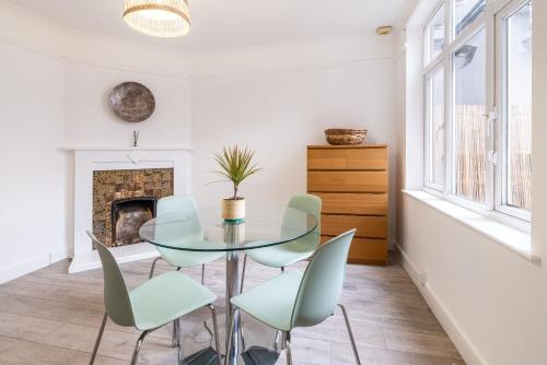 a dining room with a glass table and chairs at Aura Room - Kingsize minimalist room in Luton in Luton