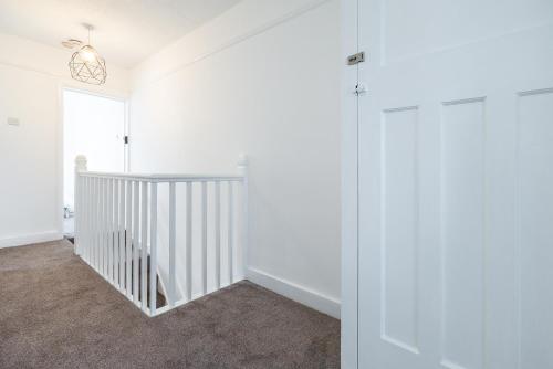 a hallway with white walls and a white door at Aura Room - Kingsize minimalist room in Luton in Luton