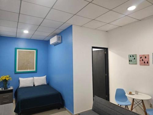 a room with a bed and a blue wall at Mono Espacio en Zona Romántica L3 in Puerto Vallarta