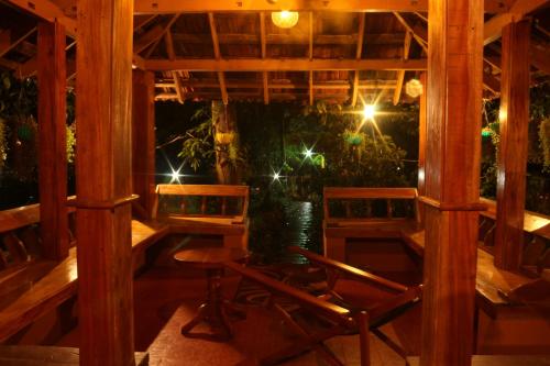 a porch with two chairs and a table and lights at Zyamadhari in Mananthavady
