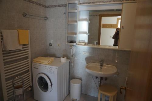 a bathroom with a washing machine and a sink at Hotel & Residence Sylvanerhof in Chiusa