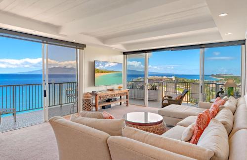 a living room with a couch and large windows at The Whaler By Maui Resort Rentals in Lahaina