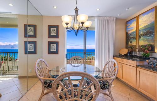 a dining room with a glass table and chairs at The Whaler By Maui Resort Rentals in Lahaina
