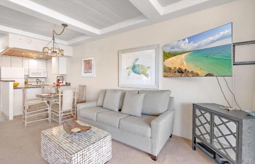 a living room with a couch and a kitchen at The Whaler By Maui Resort Rentals in Lahaina