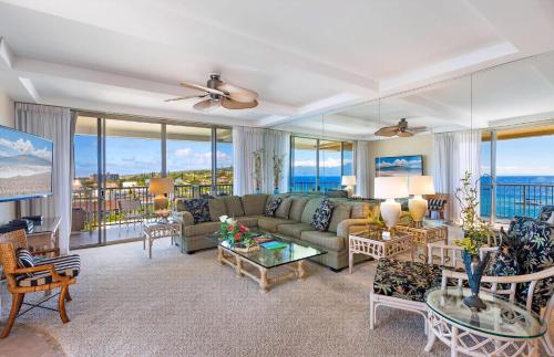 a living room with a couch and chairs and windows at The Whaler By Maui Resort Rentals in Lahaina