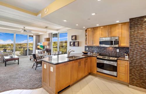 a kitchen with wooden cabinets and a living room at The Whaler By Maui Resort Rentals in Lahaina