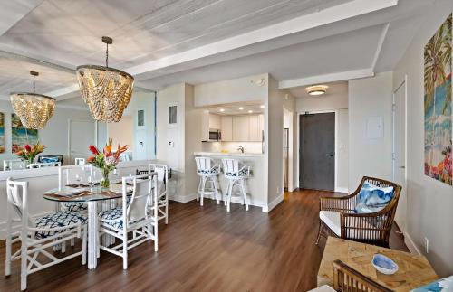 a dining room and living room with a table and chairs at The Whaler By Maui Resort Rentals in Lahaina