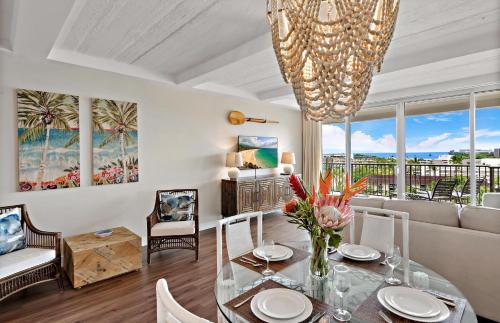 a living room with a glass table and a chandelier at The Whaler By Maui Resort Rentals in Lahaina