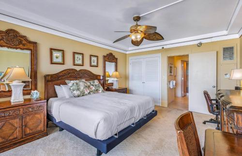 a bedroom with a bed and a desk and a ceiling fan at The Whaler By Maui Resort Rentals in Lahaina