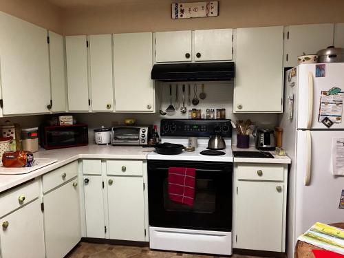 a kitchen with white cabinets and a black stove top oven at Silver Valley Getaway in Kellogg