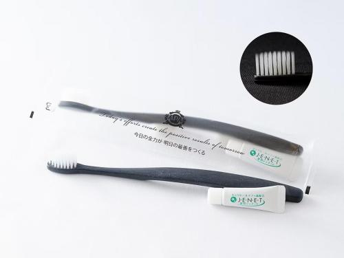 a plastic toothbrush and a toothbrush wrapper on a white background at APA Hotel Shonan Tsujido Ekimae in Fujisawa