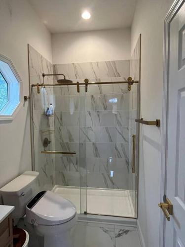 a bathroom with a shower and a toilet at The Swift Lake House in Somerset