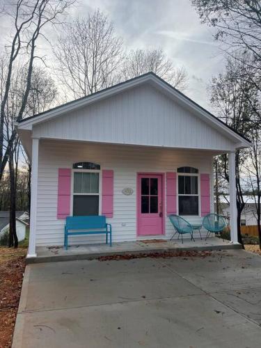 a pink and white house with a blue bench in front at The Swift Lake House in Somerset