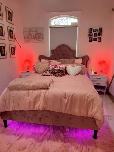a bedroom with a large bed with purple lights at The Swift Lake House in Somerset