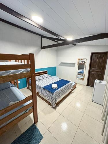 a bedroom with two bunk beds and a bathroom at Flow Guest House in Salinópolis