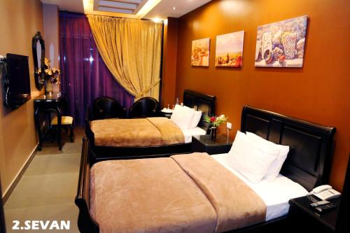 a hotel room with two beds and a desk at Layali Al Shams Hotel in ‘Anjar