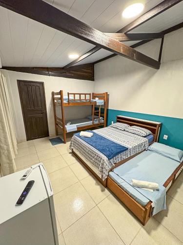 a bedroom with two twin beds and a desk at Flow Guest House in Salinópolis