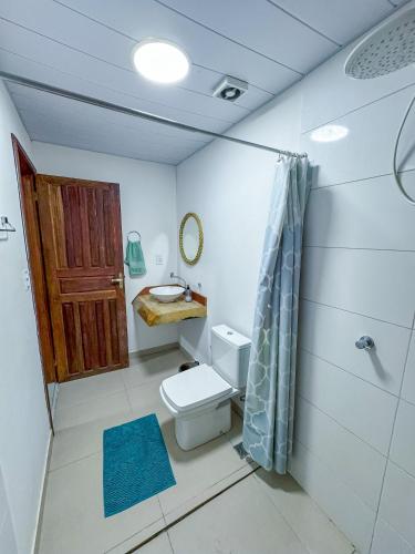 a bathroom with a toilet and a sink and a shower at Flow Guest House in Salinópolis