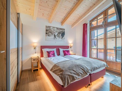 a bedroom with a bed and a large window at Petras Chalet-Apartment am Lift in Rauris
