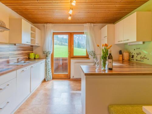 a kitchen with white cabinets and a wooden ceiling at Sonja in Scheffach
