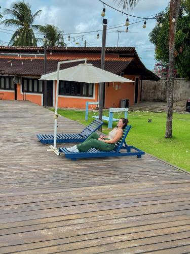 a woman laying on a beach chair on a boardwalk at Flow Guest House in Salinópolis