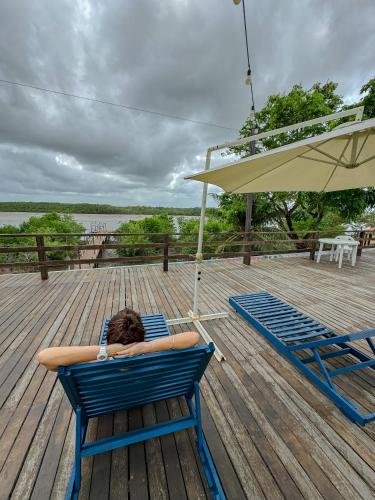 a person laying in a chair on a deck at Flow Guest House in Salinópolis