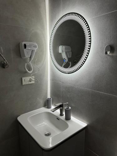 a bathroom with a sink and a mirror at Midtown Prishtina Stays in Pristina
