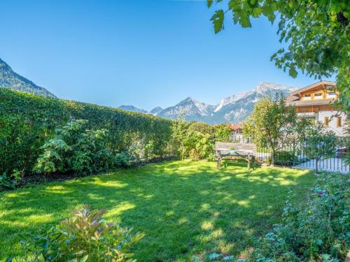 a garden with a bench and mountains in the background at Johanna und Sonja in Scheffach