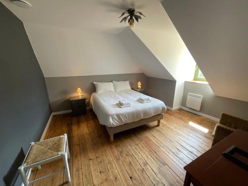 una camera da letto con un letto in mansarda con due luci di Sous les toits de la Tavarn Ty Gar a Hennebont