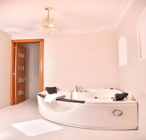 ein weißes Bad mit einer weißen Badewanne in einem Zimmer in der Unterkunft Hotel Boutique Casa Ruth en Cuenca in Cuenca