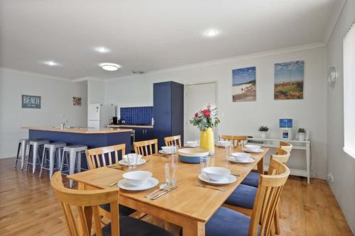 a dining room with a wooden table and chairs at Across the Way, golf and beach heaven in Dunsborough
