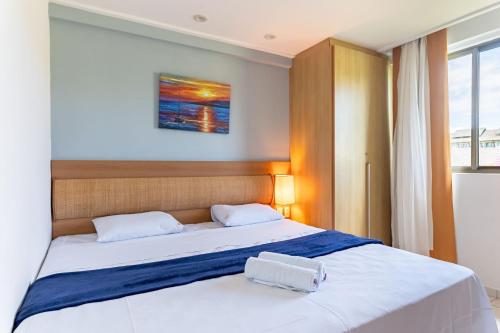 a bedroom with a bed with two white towels on it at Flat ou Bangalo Luxo Beach Class Beira Mar Muro Alto in Porto De Galinhas
