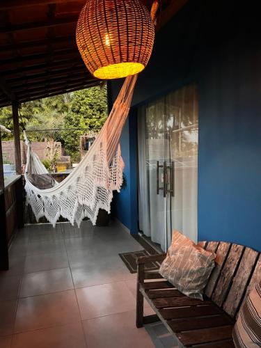 a hanging hammock in a room with a couch at Pousada Nascente do Sol in Ilha de Boipeba