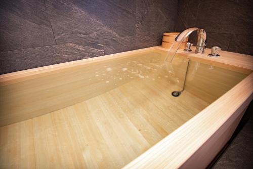 a bath tub with a faucet on top of it at NIPPONIA Sawara Merchant Town Hotel in Katori