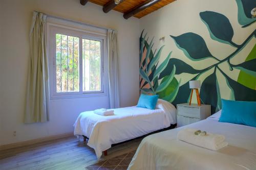a bedroom with two beds and a mural on the wall at Fliphaus Chacras De Coria - 4 Bd House Pool&bbq in Ciudad Lujan de Cuyo
