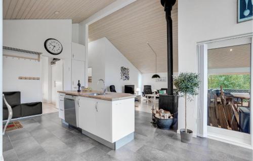 a kitchen with a sink and a clock on the wall at Holiday Home Kronvildtvej Brovst I in Brovst
