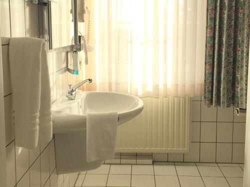 a white bathroom with a sink and a shower at Landhaus Bisping in Everswinkel