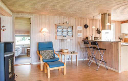 a kitchen with a table and a blue chair and a table and a tablektop at Lillebo in Brejning