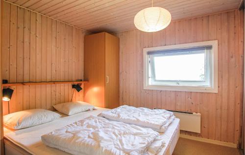 a bedroom with two beds in it with a window at Lillebo in Brejning